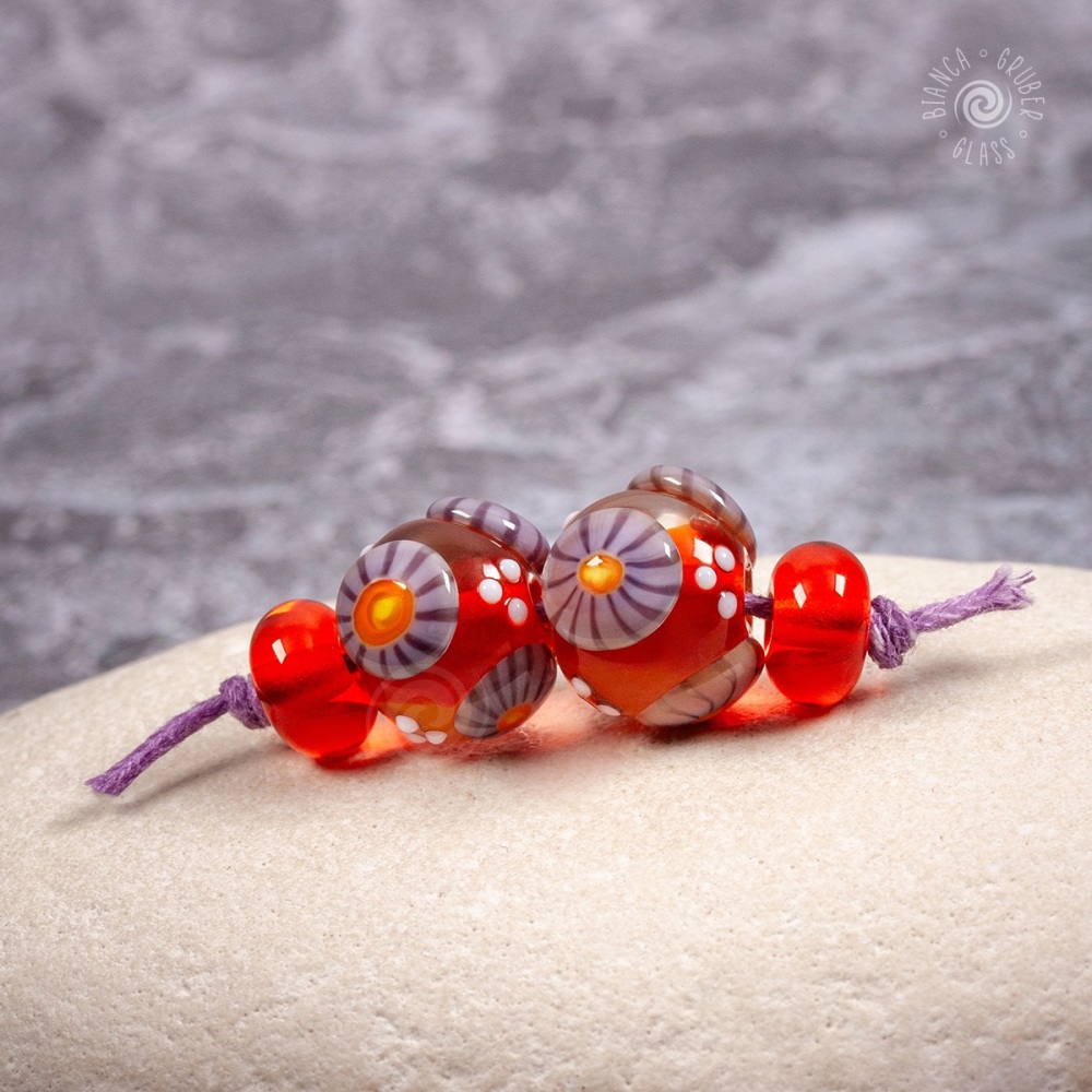 Marmalade orange cored, clear encased beads with purple murrini