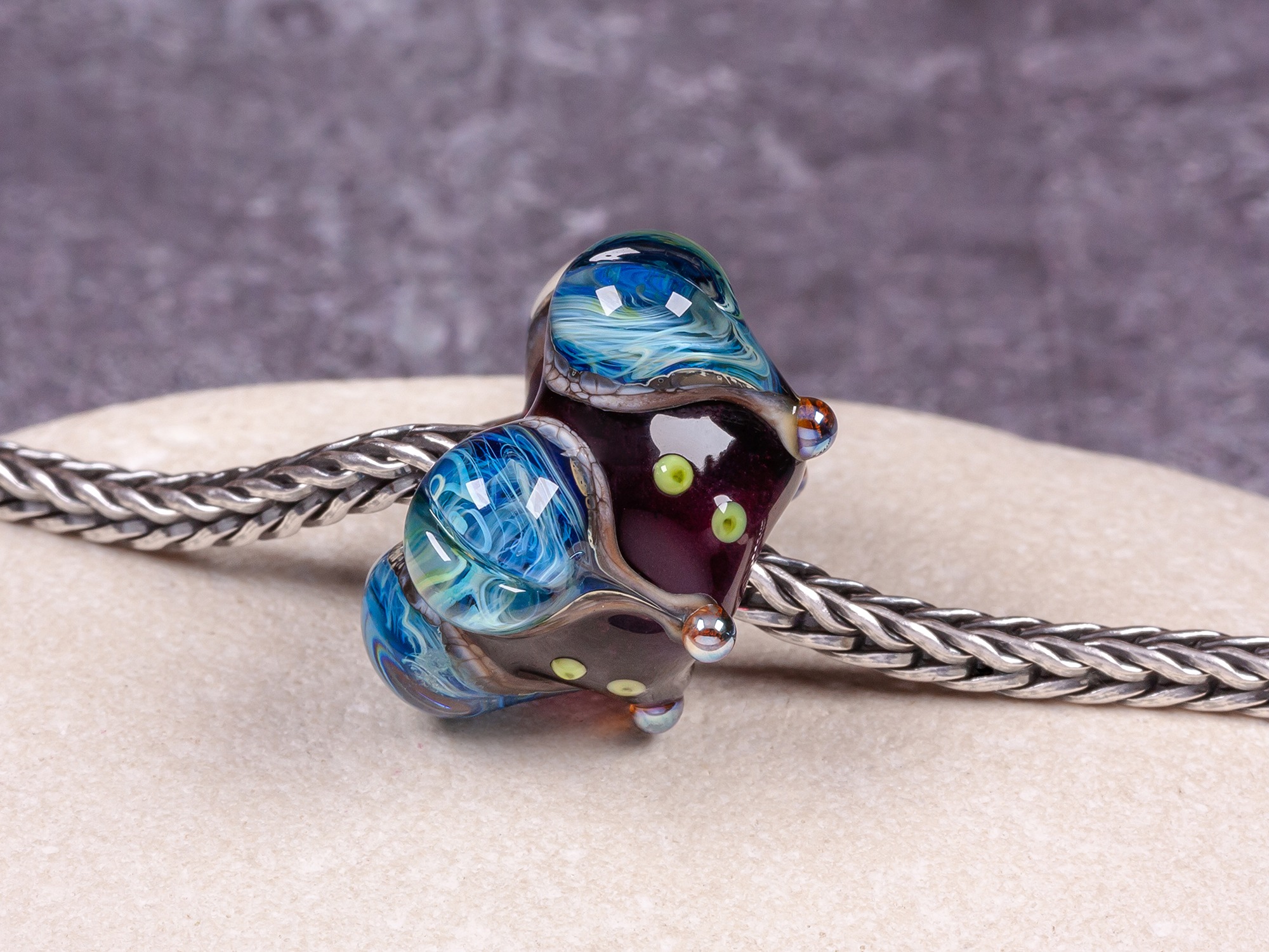 Depp transparent purple big hole lotus bead with swirled silver blue glass decoration.