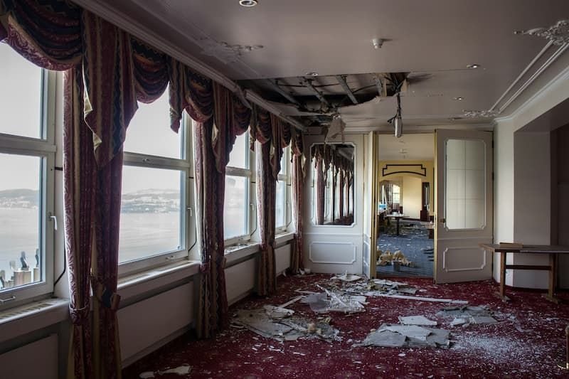 Water damage from ceiling in a house corridor, emphasizing the need for insurance.