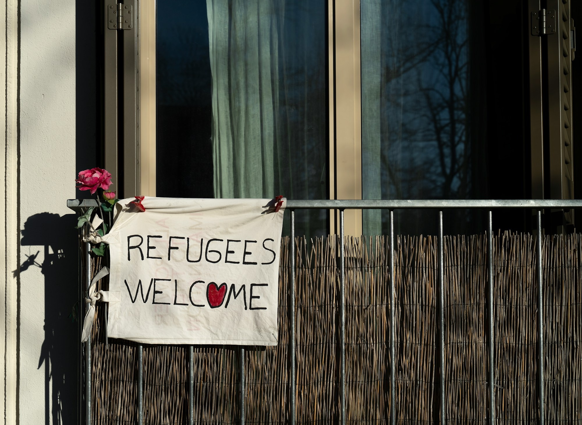 a-sign-that-says-refugees-welcome-on-a-building-cw_CxgiymqY.jpg