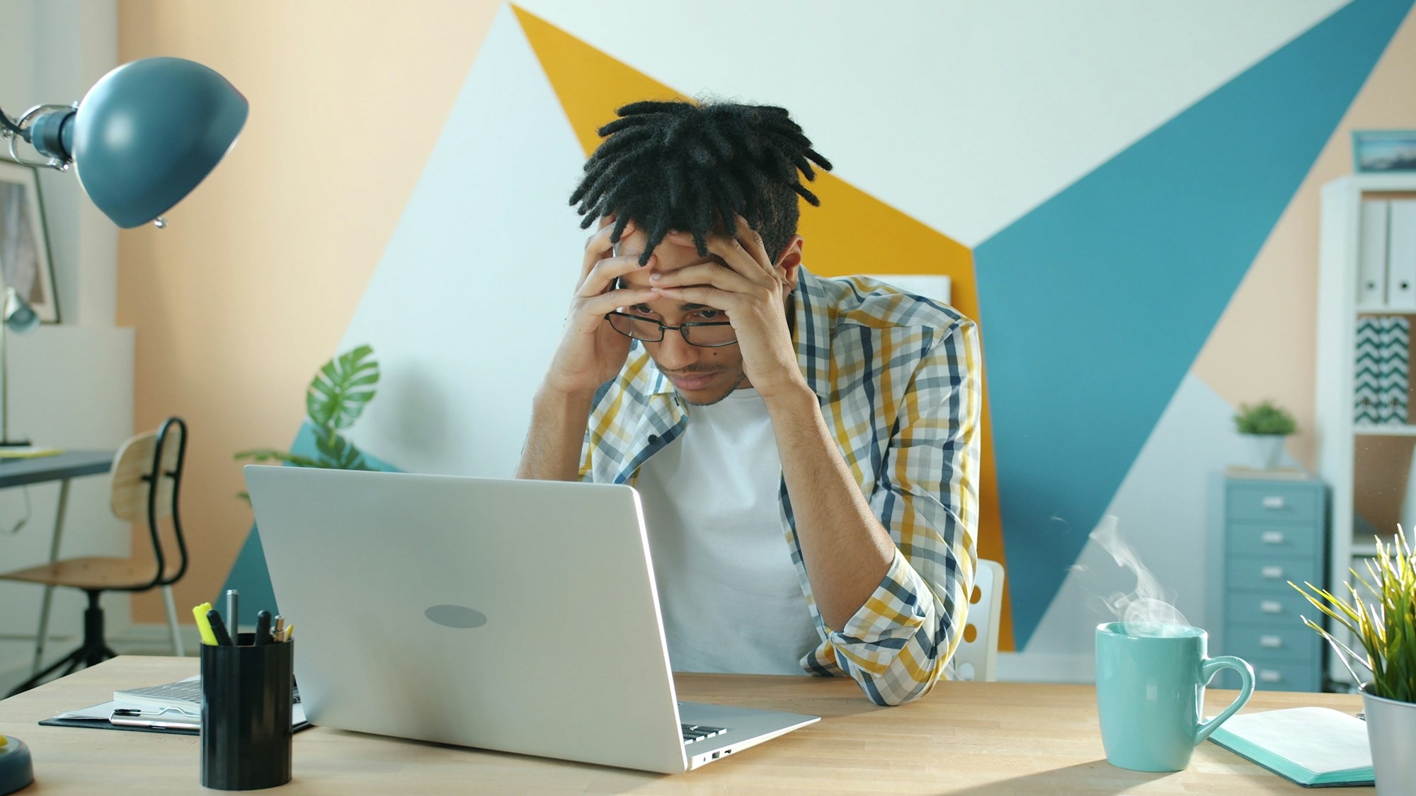 Man sitting at a desk with his head in his hands