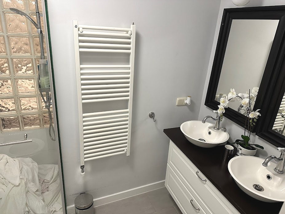 Spotless bathroom cleaning in a Nerja holiday apartment, featuring polished chrome fixtures, white porcelain sinks, and fresh towels.