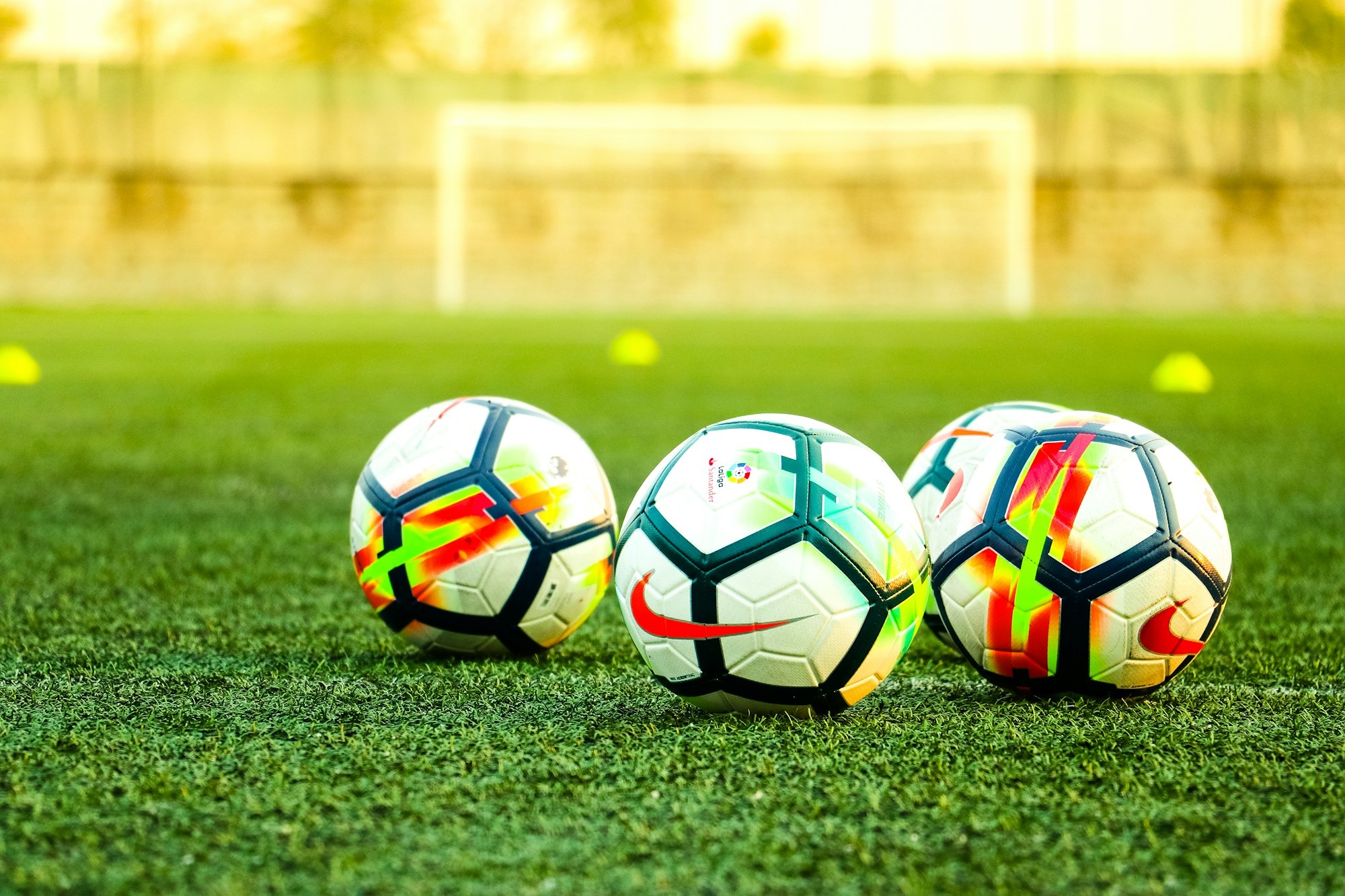 three-white-and-black-soccer-balls-on-field-JO19K0HDDXI